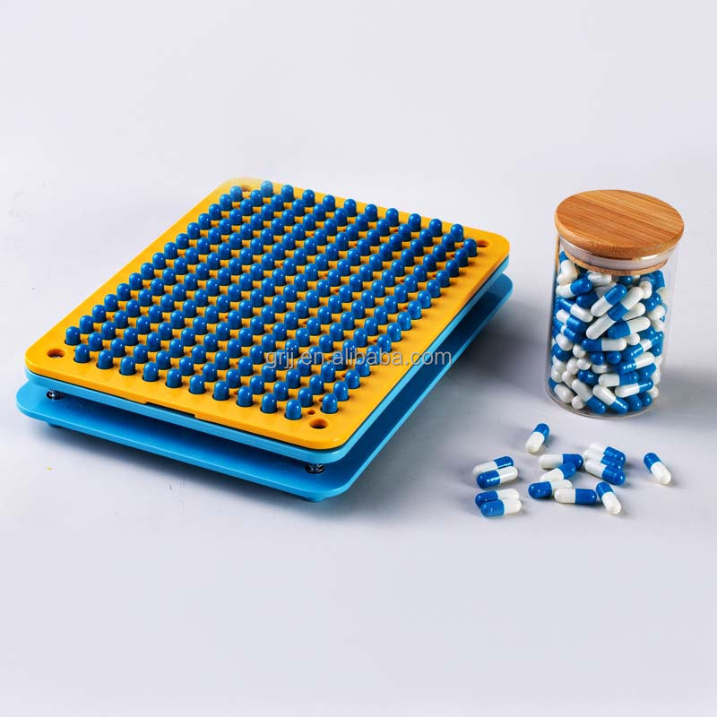 Hands loading capsules into the filling tray